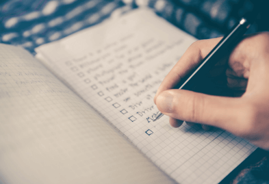 hand writing a list in a notebook